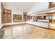 Open living room showcasing hardwood floors and kitchen access with many windows for natural light at 8812 Blue Mountain Pl, Highlands Ranch, CO 80126