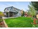 Expansive backyard with covered patio, playset, mature trees, and lush lawn at 14194 W Amherst Ave, Lakewood, CO 80228