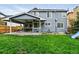 Large grassy backyard with a covered patio, offering ample space for outdoor activities at 14194 W Amherst Ave, Lakewood, CO 80228