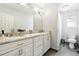 Bathroom featuring double sinks, a large mirror, and a separate toilet and shower area at 14194 W Amherst Ave, Lakewood, CO 80228