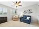 Bright, carpeted bedroom with blue loveseat and chair, ceiling fan, and window with white shutters at 14194 W Amherst Ave, Lakewood, CO 80228