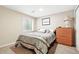 Cozy carpeted bedroom featuring a window, dresser, and patterned bedding at 14194 W Amherst Ave, Lakewood, CO 80228
