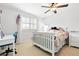 Bright bedroom with white furniture, a ceiling fan, and a large window with shutters at 14194 W Amherst Ave, Lakewood, CO 80228