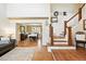 Welcoming entryway with hardwood floors, staircase, and a view into the formal dining room at 14194 W Amherst Ave, Lakewood, CO 80228
