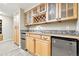 Basement wet bar with wooden cabinetry, a stone backsplash, and tile flooring at 14194 W Amherst Ave, Lakewood, CO 80228