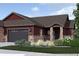 Charming home exterior showcasing stone accents, a two-car garage, and well-manicured landscaping at 881 W 128Th Pl, Westminster, CO 80234
