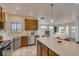 Bright kitchen with stainless steel appliances, wood cabinets, and center island overlooking living area at 881 W 128Th Pl, Westminster, CO 80234
