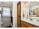 Cozy bathroom features a wood vanity, a large mirror and a tiled shower at 273 S 13Th Ave, Brighton, CO 80601