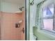 Bathroom with a tiled pink shower stall, window and toiletry storage at 273 S 13Th Ave, Brighton, CO 80601