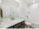 Well-lit bathroom featuring a single sink, a large mirror, and a shower-tub combo with white tiling at 17848 Gallup St, Broomfield, CO 80023