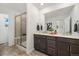 Modern bathroom featuring double sinks, a large mirror, and a walk-in shower with a built-in bench at 17848 Gallup St, Broomfield, CO 80023