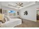 Bright bedroom featuring a ceiling fan, tray ceiling, neutral decor and a large window with neighborhood views at 17848 Gallup St, Broomfield, CO 80023