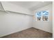 A well-lit walk-in closet featuring carpeted flooring, bright white walls, and a window for natural light at 17848 Gallup St, Broomfield, CO 80023