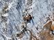 High angle aerial view of home nestled among snow covered trees with winding driveway, highlighting seclusion at 97 Hedges Cir, Sedalia, CO 80135