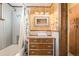 Bright bathroom with a tub, shower, sink with vanity, wood-paneled walls, and charming, rustic accents at 97 Hedges Cir, Sedalia, CO 80135