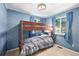 Cozy bedroom with a built-in bunk bed, soft blue wallpaper, two windows, and neutral carpeting at 97 Hedges Cir, Sedalia, CO 80135