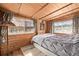 Serene bedroom with wood paneling, platform bed, and large windows showcasing picturesque winter views at 97 Hedges Cir, Sedalia, CO 80135