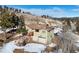 Two-story mountain home featuring a two-car garage and wooden deck, all set against a rocky, snowy landscape at 97 Hedges Cir, Sedalia, CO 80135