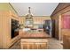Bright kitchen featuring stainless steel appliances, an island with stovetop, and natural wood cabinets at 97 Hedges Cir, Sedalia, CO 80135