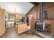 Farmhouse kitchen featuring wood cabinets, stainless steel appliances, a brick accent wall, and a wood-burning stove at 97 Hedges Cir, Sedalia, CO 80135