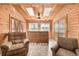 Cozy sunroom with wood-paneled walls, skylights, ceiling fan and comfortable seating area at 97 Hedges Cir, Sedalia, CO 80135