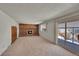 Living room with brick fireplace, sliding glass door to patio, and carpeted floors at 13769 Omega Cir, Lone Tree, CO 80124