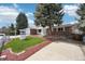 View of a brick ranch home with mature landscaping and a well feature at 3089 S Quintero Way, Aurora, CO 80013