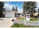 Charming brick ranch home with a well-manicured lawn, white picket fence, and mature trees at 3089 S Quintero Way, Aurora, CO 80013