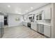 Bright, renovated kitchen featuring gray cabinets, stainless steel appliances, and wood-look flooring at 3089 S Quintero Way, Aurora, CO 80013
