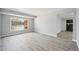 Bright living room with large window and new gray flooring leading to the fireplace at 3089 S Quintero Way, Aurora, CO 80013