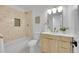 Well-lit bathroom featuring a modern vanity, stylish mirror, and tiled shower and tub at 1557 S Owens St # 59, Denver, CO 80232