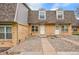 Charming brick townhome featuring a gravel yard, a concrete walkway, and prominent dormer windows at 1557 S Owens St # 59, Denver, CO 80232