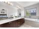 Bright bathroom featuring a double vanity, a bathtub, and tile accents around the large window at 4557 Stuart St, Denver, CO 80212
