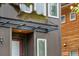 Front entry with porch cover, exterior fixture and wood siding on adjacent home at 4557 Stuart St, Denver, CO 80212