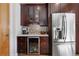 Wet bar area with wine cooler, stainless steel refrigerator, glass front cabinets and mosaic backsplash at 4557 Stuart St, Denver, CO 80212