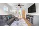 Cozy living room with a gray sofa, ceiling fan, fireplace, and a large window to let the light shine through at 4557 Stuart St, Denver, CO 80212