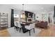 Open-concept living and dining area with a modern fireplace, wood floors, and plenty of seating at 4557 Stuart St, Denver, CO 80212