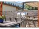 Patio featuring a stainless steel grill, outdoor dining table, and comfortable seating beneath an open pergola at 4557 Stuart St, Denver, CO 80212