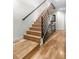 Modern staircase with wooden steps, black metal railings, and light hardwood floors creates a clean, contemporary design at 4557 Stuart St, Denver, CO 80212