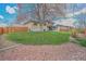 An expansive backyard boasting lush lawn space, a mature tree, and a charming patio area for outdoor enjoyment at 2194 S Braun Way, Lakewood, CO 80228