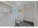 This renovated bathroom showcases elegant black tile floors, white vanity, and a modern shower with clear door at 2194 S Braun Way, Lakewood, CO 80228