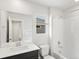 Clean bathroom with gray vanity, a shower-tub combo, and a window allowing natural light to filter in at 553 Homestead Ave, Brighton, CO 80601