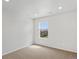 Neutral carpeted bedroom with natural light streaming through a window overlooking the neighborhood at 553 Homestead Ave, Brighton, CO 80601