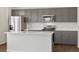 Stylish kitchen boasts stainless steel appliances, grey cabinets, and a pristine white countertop at 553 Homestead Ave, Brighton, CO 80601