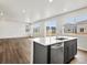 Open kitchen with a center island and modern appliances adjoins a spacious living room at 553 Homestead Ave, Brighton, CO 80601