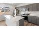 Modern kitchen featuring gray cabinets, stainless steel appliances, quartz countertops, and kitchen island at 553 Homestead Ave, Brighton, CO 80601
