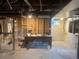 An unfinished basement area with a desk, exposed pipes, and utilities at 1690 Spruce St, Denver, CO 80220