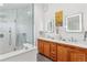 Modern bathroom features a double vanity, a glass shower, and eye-catching lighted mirrors and lighting at 1690 Spruce St, Denver, CO 80220