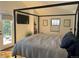 Bright bedroom features a four-poster bed, with a television, a plant, and double doors leading to the outside at 1690 Spruce St, Denver, CO 80220