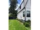 The house exterior showing white siding with black trim, a green lawn, and garden landscaping at 1690 Spruce St, Denver, CO 80220